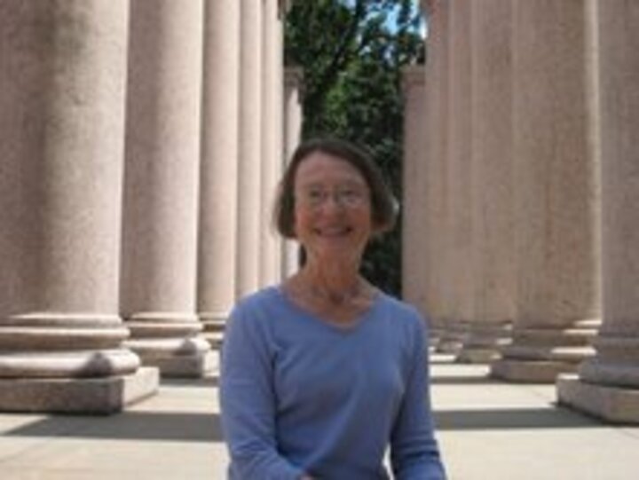 Dr. Flood stands alone with stone pillars in the background